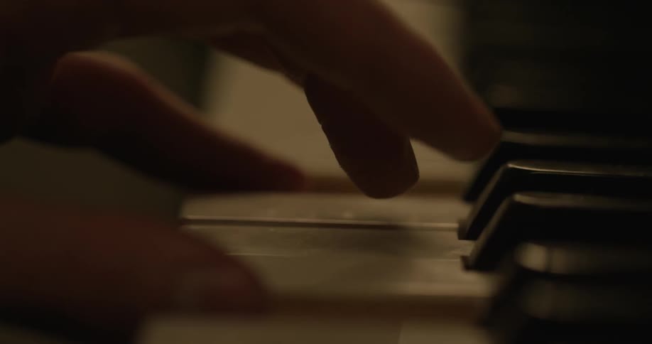 Hands are shown playing a piano