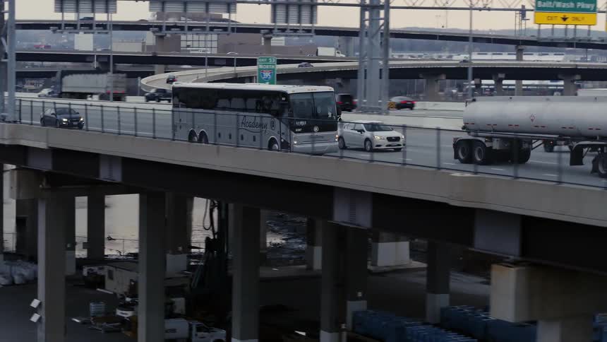 A bus drives on a freeway overpass in traffic