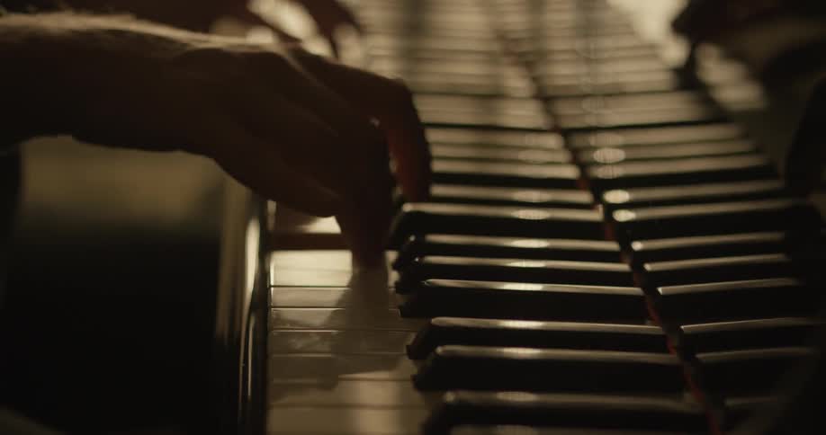 A pianist's hands are shown playing a piano