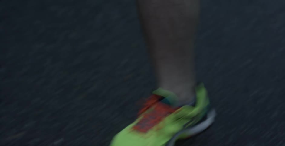 A jogger's feet slam the asphalt as they run