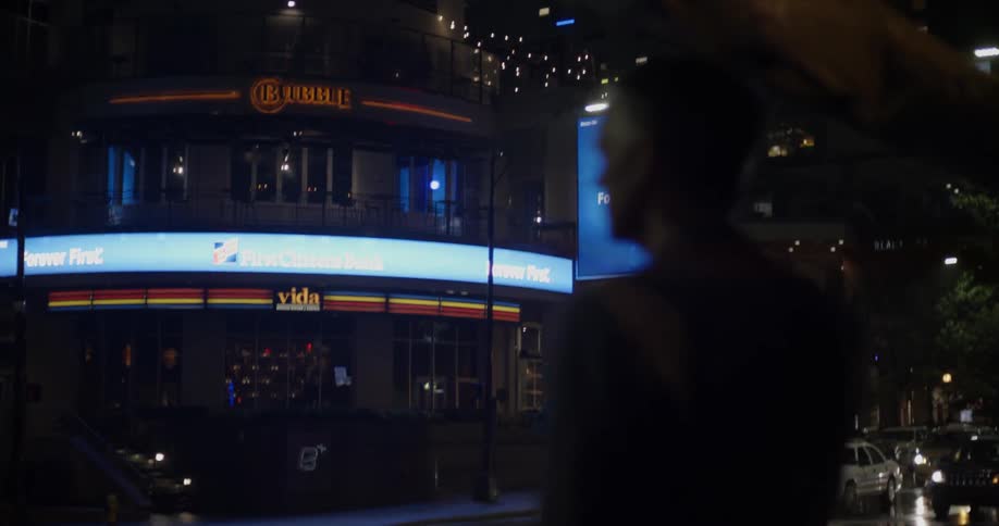A man holding an umbrella looks out at a street