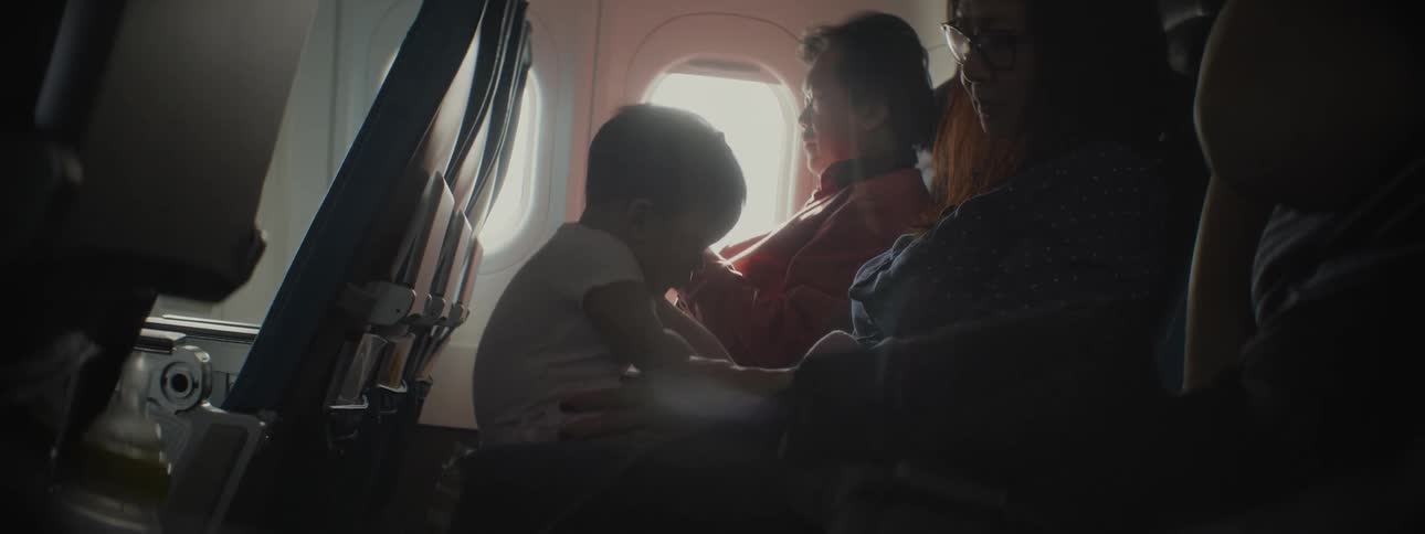 Two women sitting on a plain holding a baby
