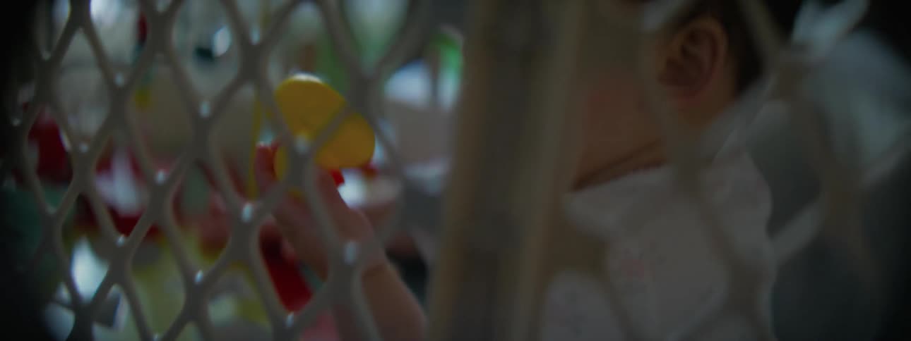A baby is chewing on a rubber ducky