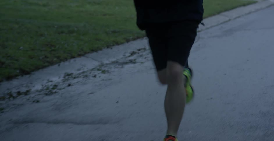 A man is running in the street near some homes