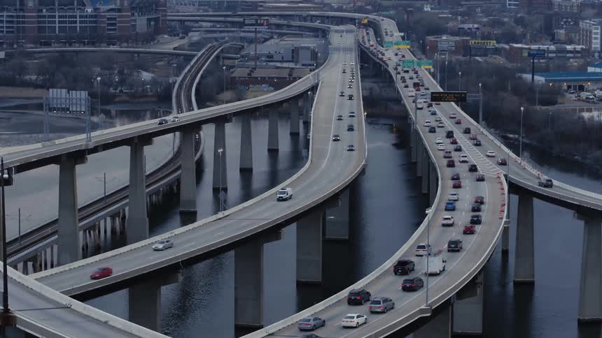 Vehicles driving over large over freeways that are suspended in the air