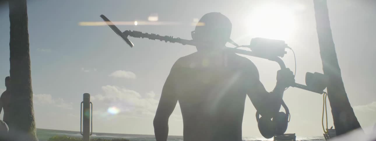 A man carries a metal detector on his shoulder
