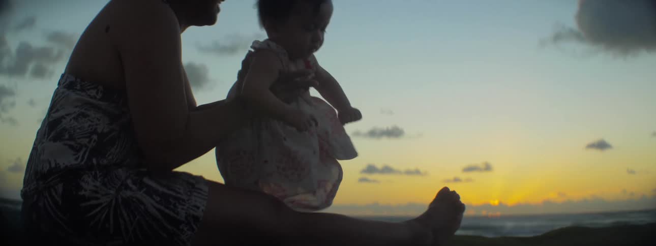 A woman is with a baby on a windy day on the beach