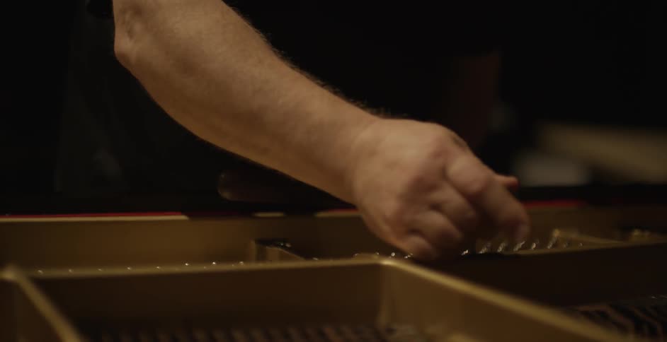 A man is fixing a piano