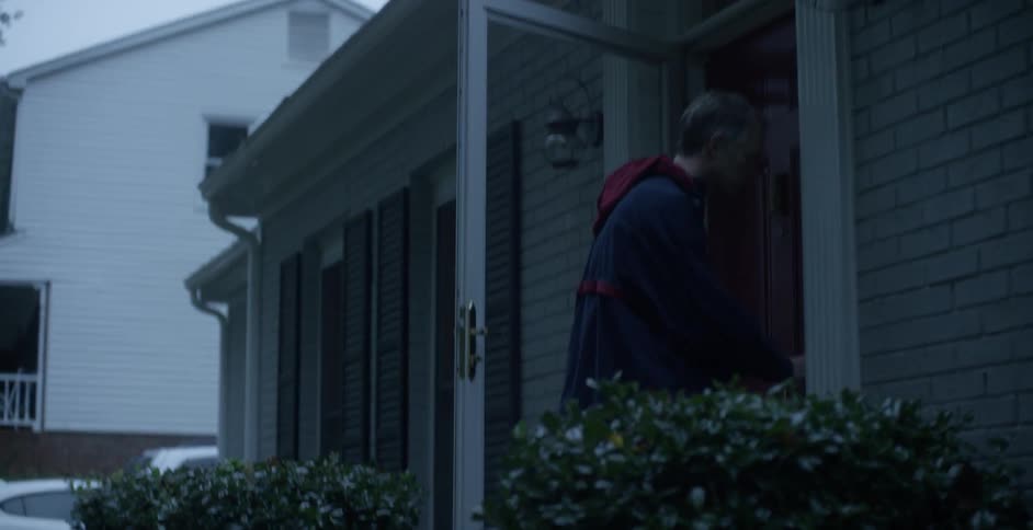 A man exits his home and locks the door