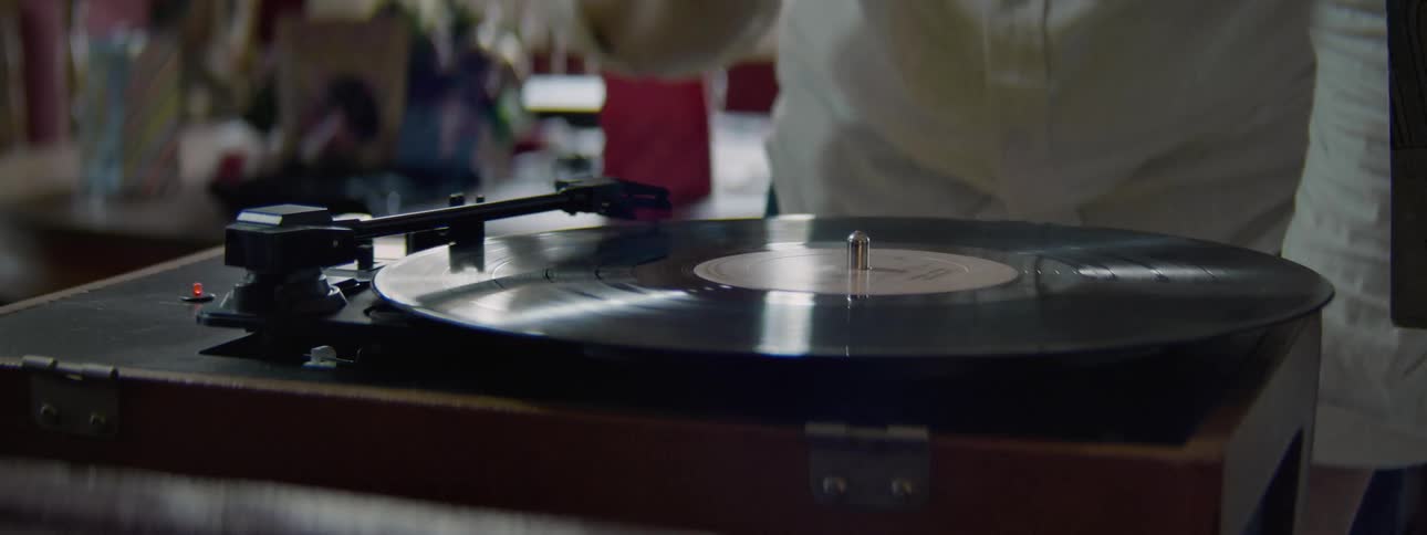 A person puts a record on a small turntable