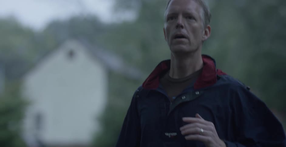 A man in a blue coat jogs down the road