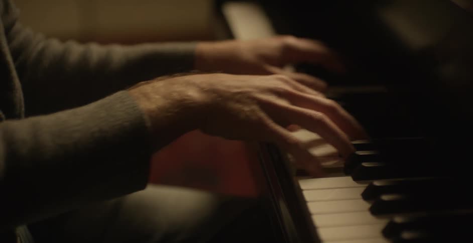 A man closes his eyes while playing the piano
