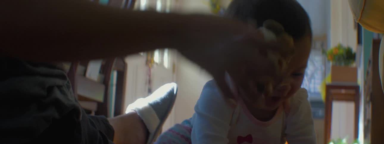 Baby waving its arms and playing with an adult