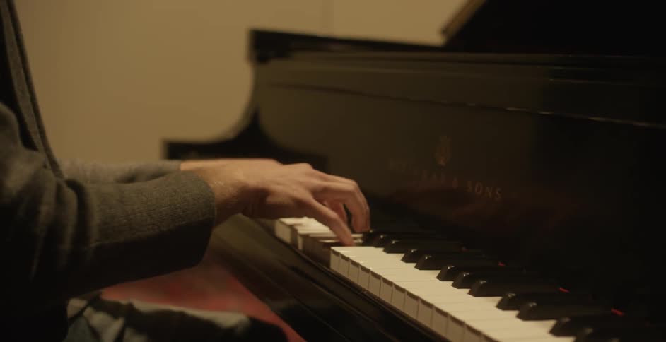 A man is playing the piano sitting down