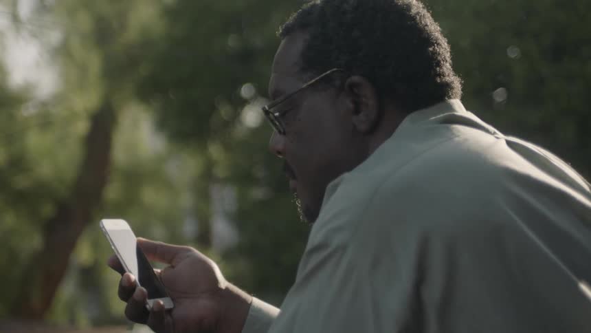 A man stares at his phone outside