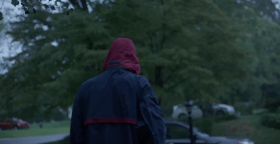 A man puts his hood on and begins stretching