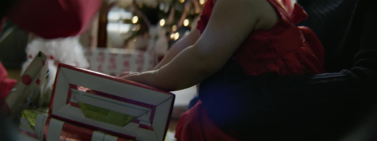 A woman opens christmas presents for a baby