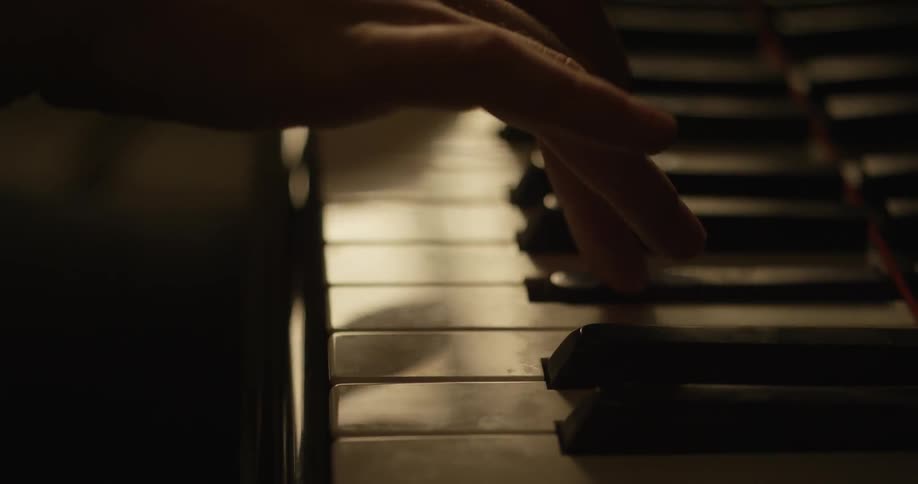 Hands slowly play a piano