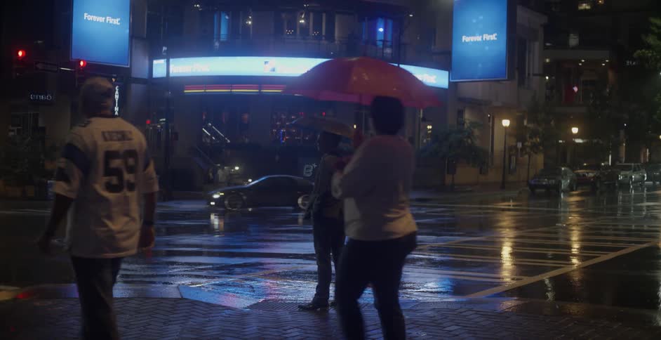 Person stands on a busy street corner at night