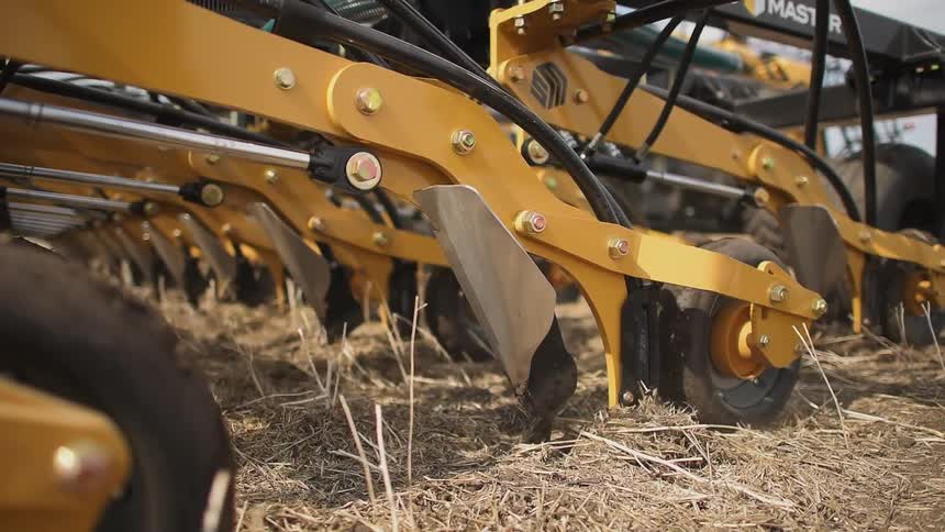 The picks from the farm vehicle dig into the dirt
