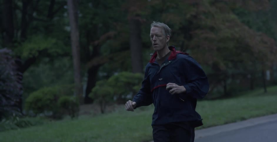 A man is running outside in his neighborhood
