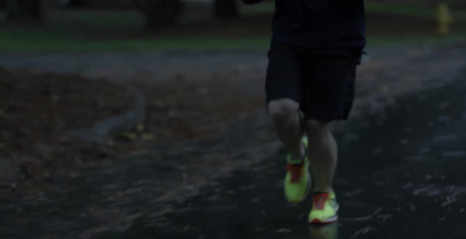 A man is jogging through his neighborhood