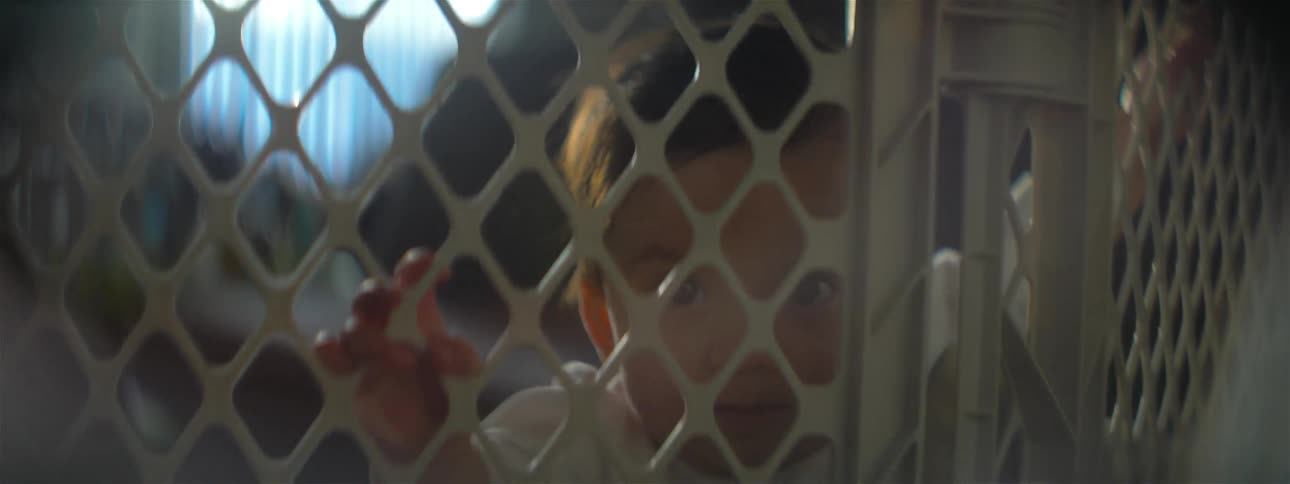 Baby standing next to a gate