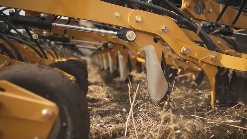 Farm equipment tills the field