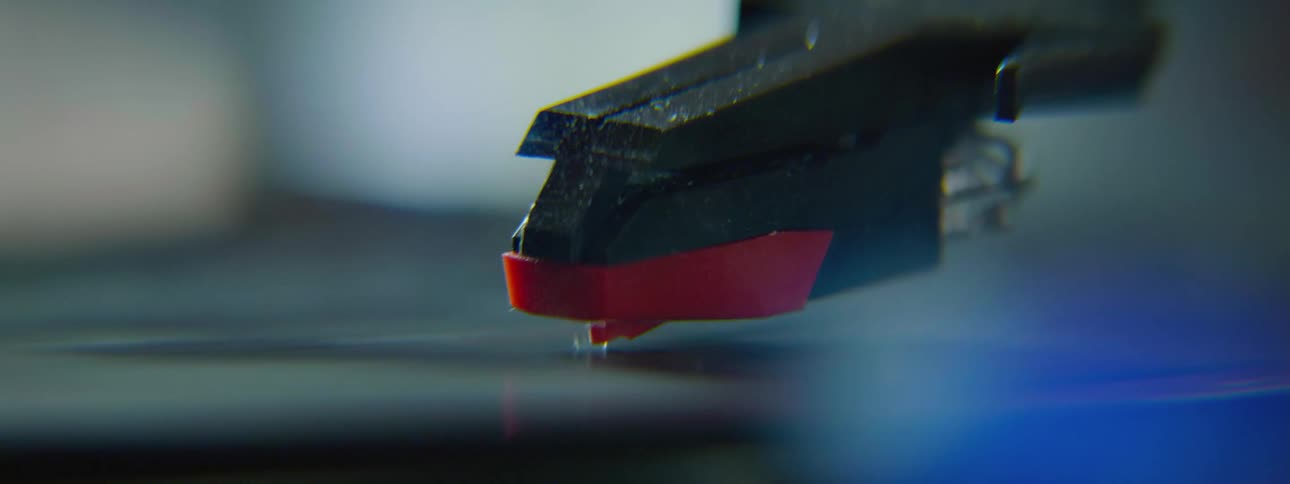 The tone arm of a record player moves up and down on