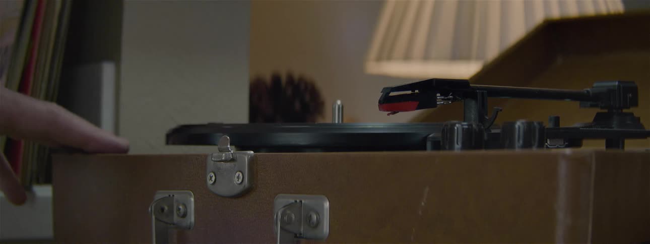 A person opens up the lid on a record player