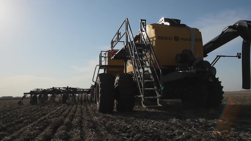 Planting and seeding equipment moves over a farm field