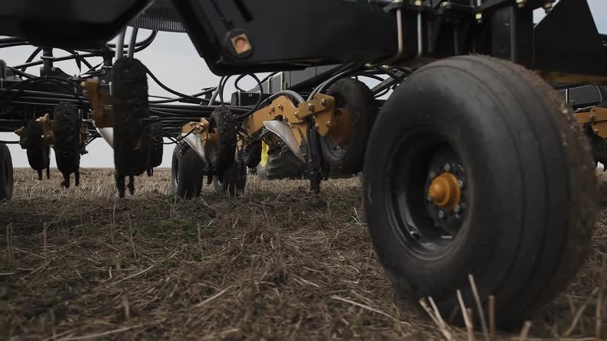 A large plow rolls over farmland