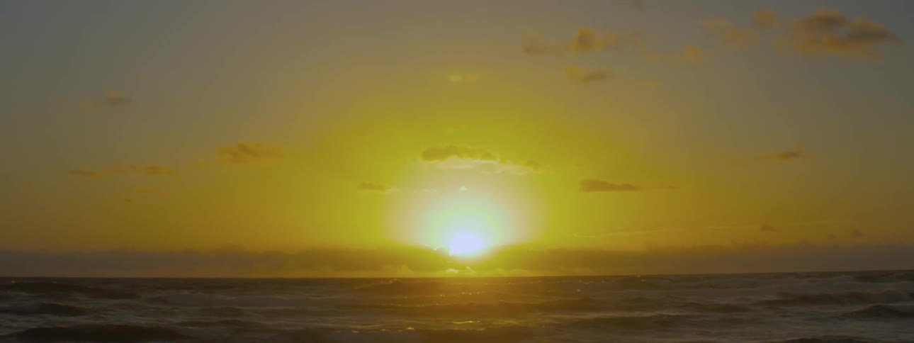 Sun rising over flowing water