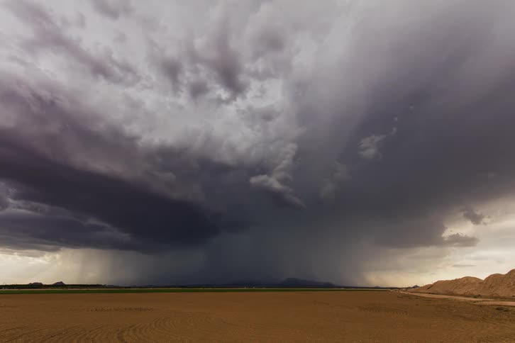 Storm clouds rotate and pass over an open field