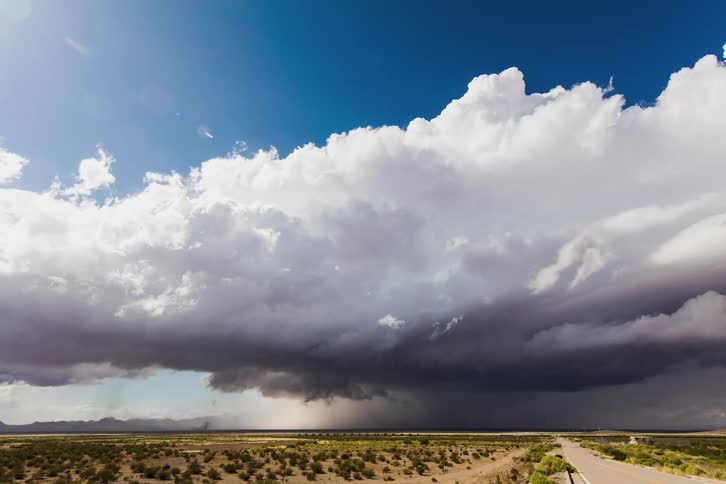 Storm clouds form and move across a plain