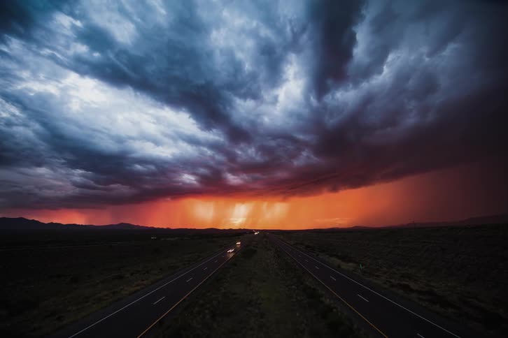 Cars speeding on a country highway at sunset