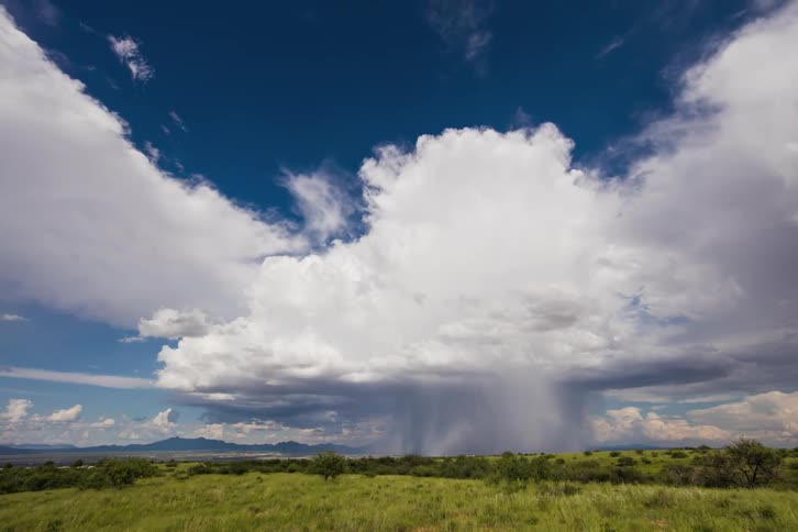 Large clouds move over the green field