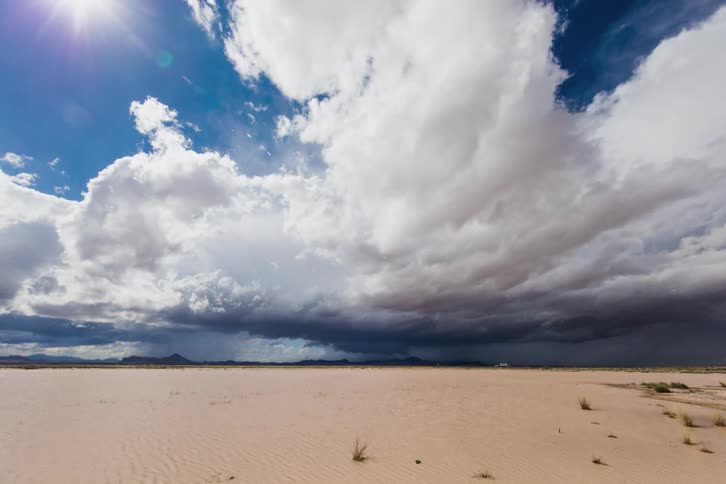 Clouds roll over a beach near a highway