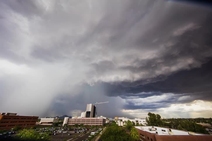 Storm clouds pour rain over a city ahead