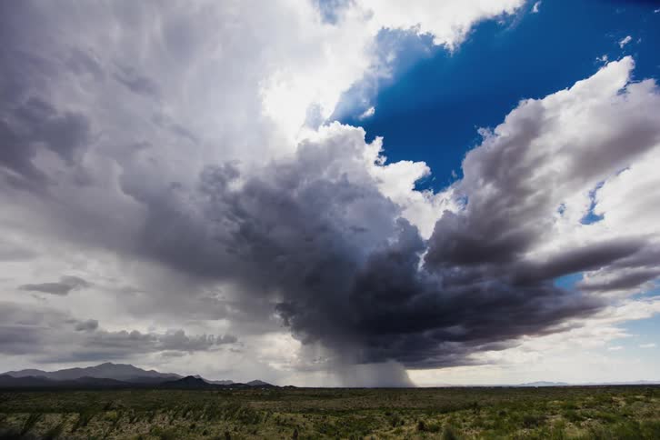 Rain clouds moving over plains with the sun partly shining