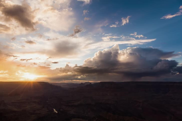 Clouds roll over a desert as the sun rises