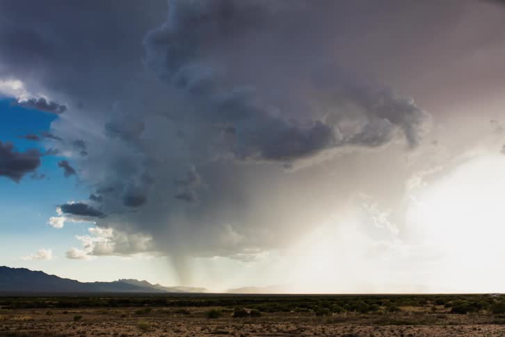 Rain clouds moving over plains with the sun partly shining