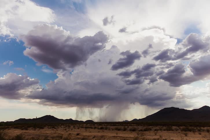 Rain clouds moving over hilly plains