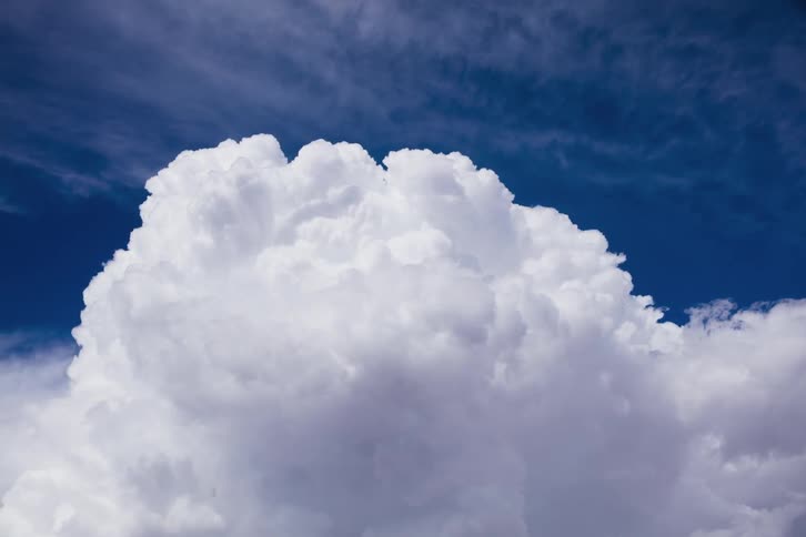The large clouds move across the blue sky