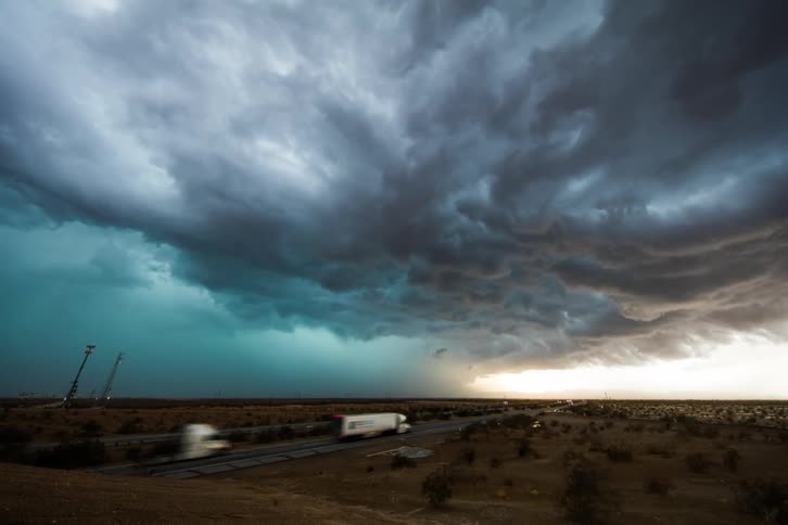 Storm clouds form and move across a roadway
