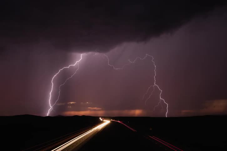 Lightning storm flashing over a busy country road