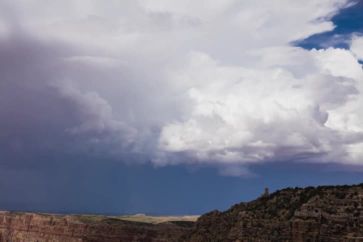 Clouds roll across the sky over a canyon