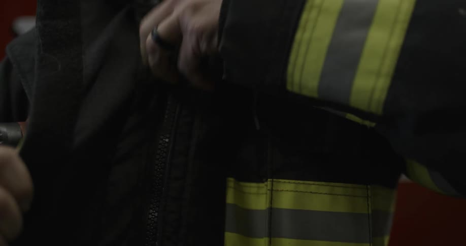 A fireman zips up his coat