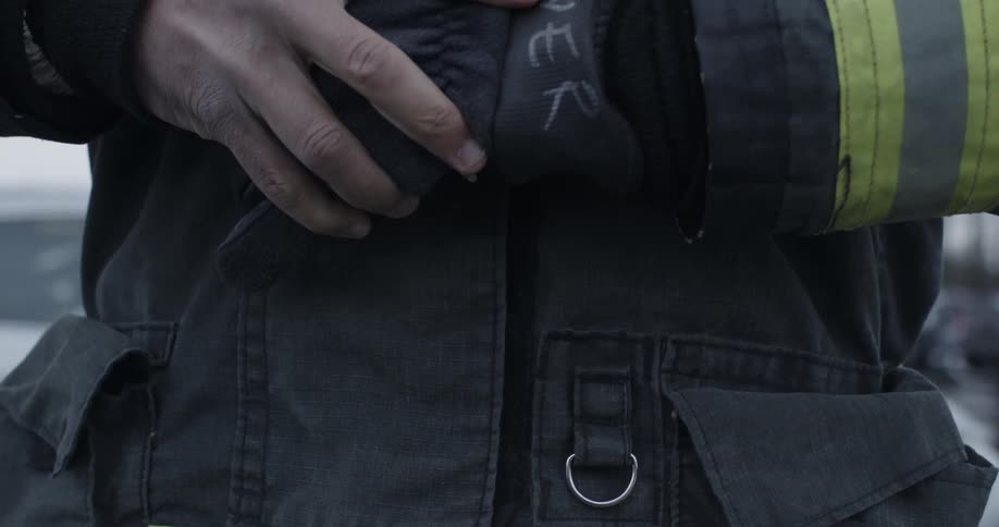 A firefighter is putting on a glove