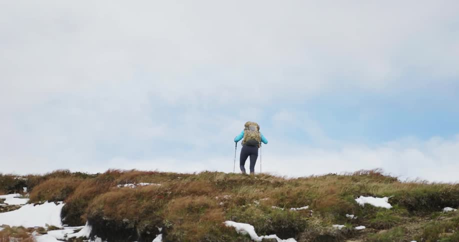 A person hiking over a snowy grassy area